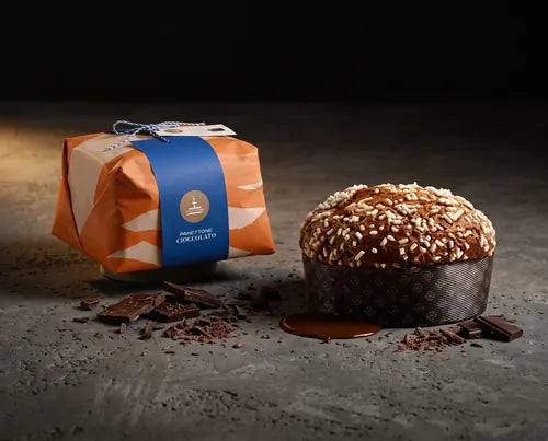 Panettone de chocolate de Fiasconaro envuelto en papel naranja junto a la pieza