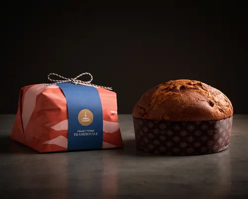 Panettone tradicional de Fiasconaro envuelto en papel junto a una porción